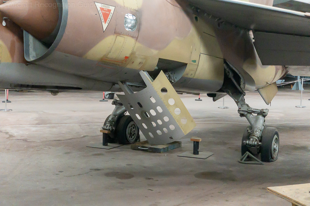 The complex main landing gear of the Mirage F1 has a claw-like appearance. In front are perforated speed brakes. Image