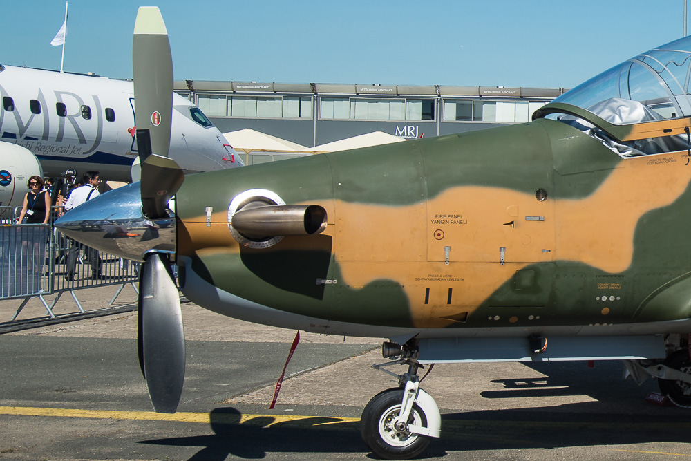 Detail of the TAI Hürkuş nose. Note the relatively long nose gear doors, curved up underside of the fuselage towards the front and cut-off prop blades. Image